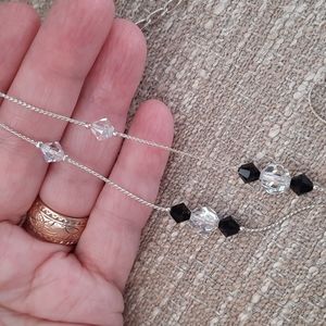 Faceted crystals and black stones on silver chain.